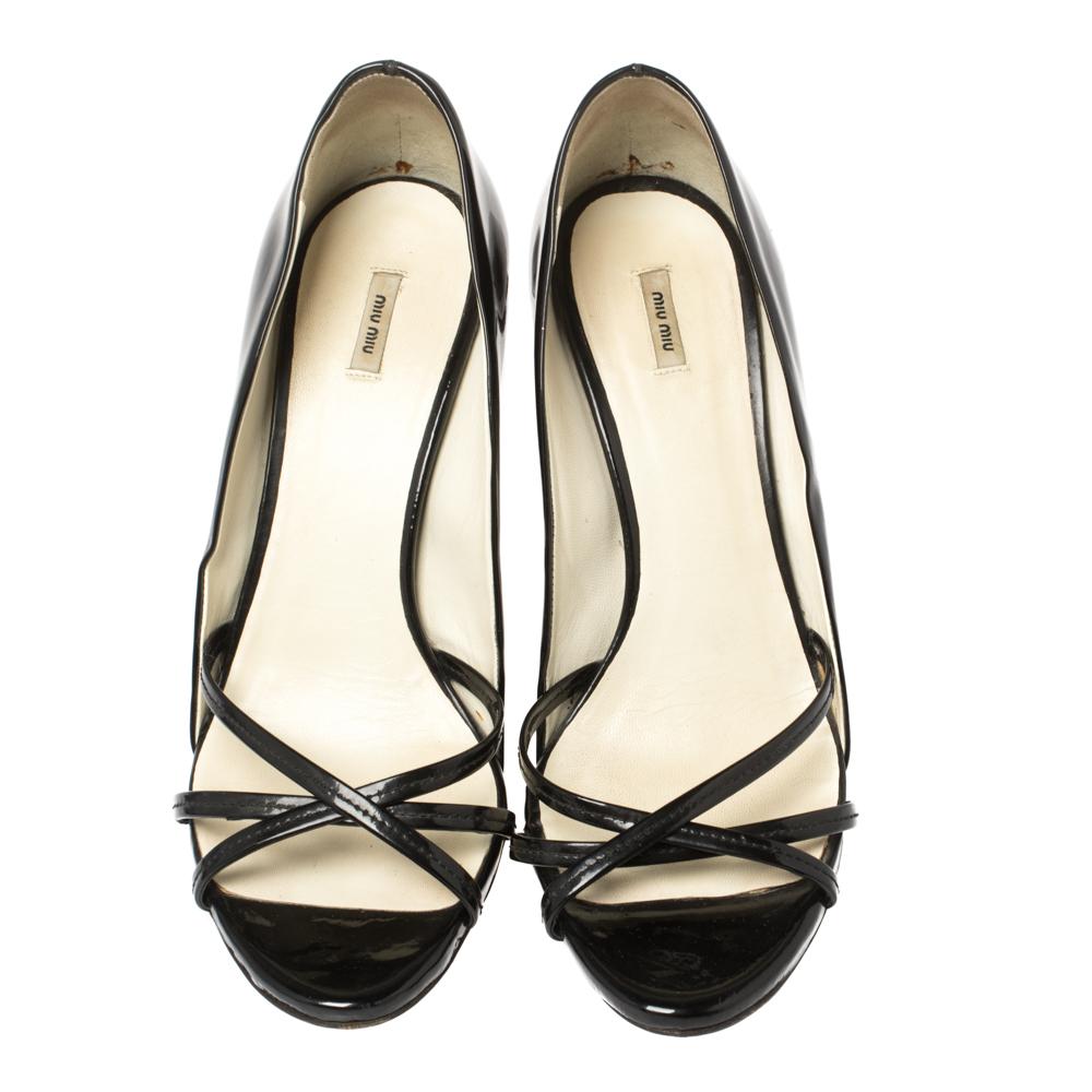 We can't stop gushing over this amazing pair of sandals from Miu Miu. They have been crafted from patent leather and styled in a lovely design. The black-hued sandals come with open-toes, strappy uppers, closed counters, and 11 cm heels embellished