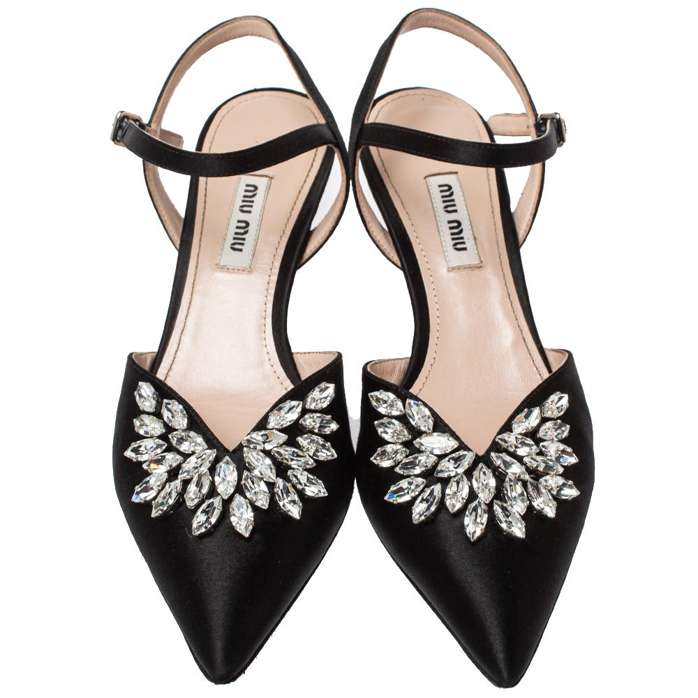 You'll love these sandals from Miu Miu as they bring a timeless appeal. They flaunt pointed toes graced with crystal embellishments, buckle ankle fastening, and 5.5 cm heels. The black sandals are just perfect to nail a refined look.

Includes: