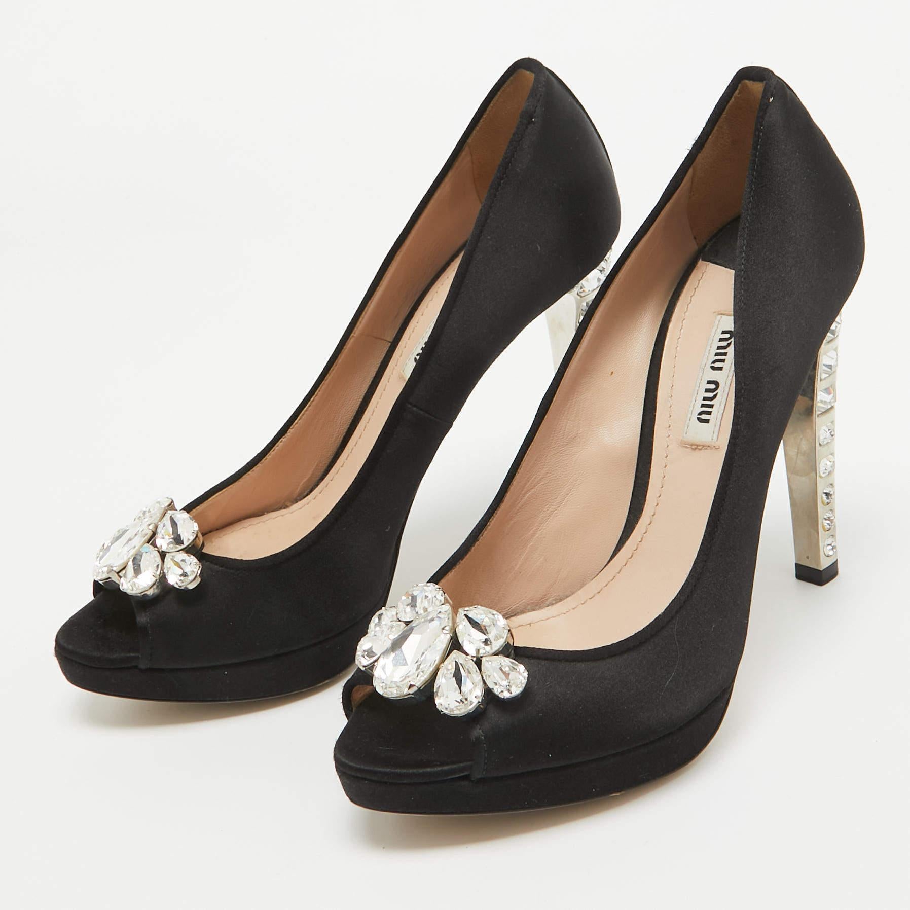 The 11.5cm heels and platforms of this pair of Miu Miu pumps will elevate you with ease. Beautified with crystal embellishments it is eye catching and alluring. These shoes are made from satin into a peep toe silhouette and feature silver tone
