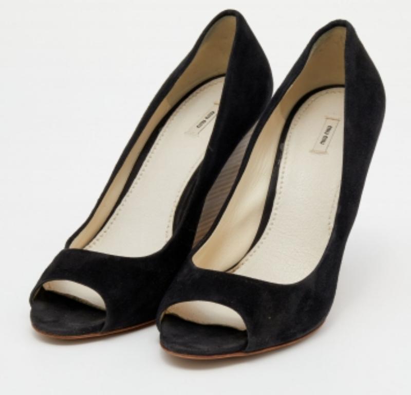 Ces escarpins de la maison Miu Miu sont conçus pour vous apporter confort et style à la fois. Elles sont réalisées en daim noir et agrémentées de peep toes, d'une doublure en cuir et de talons compensés.