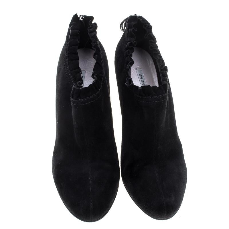 Eine Mischung aus Stil und kühner Schlichtheit, diese Stiefelette von Miu Miu wird sowohl Ihre Freizeit- als auch Ihre Abendgarderobe gekonnt ergänzen. Die aus schwarzem Wildleder gefertigten Stiefel zeichnen sich durch ein interessantes, in Falten