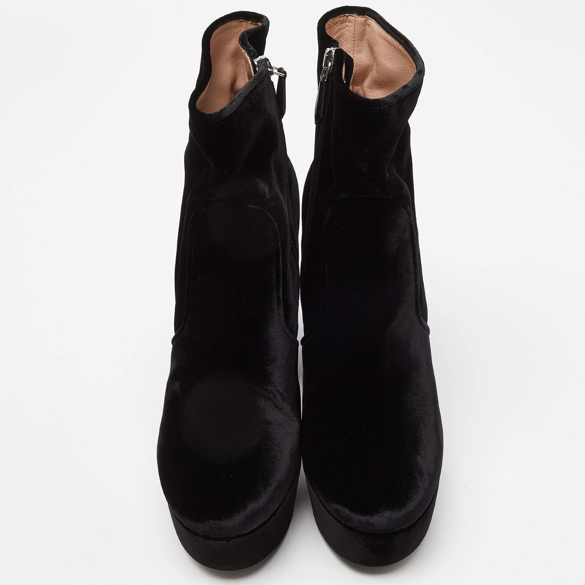 Diese Miu Miu Stiefel sind ein perfektes Paar stilvoller und mühelos auffälliger Schuhe, die Sie durch alle Jahreszeiten und Anlässe begleiten werden. Sie sind ein Muss in Ihrer Sammlung. Die aus schwarzem Samt gefertigten Stiefeletten haben einen
