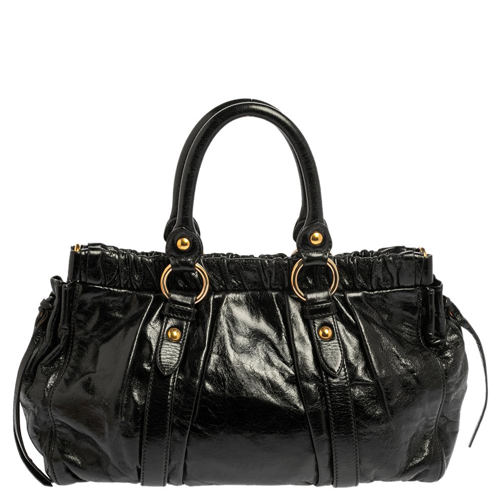 Verlieben Sie sich sofort in diese verführerische Tote von Miu Miu. Die aus Vitello Lux Leder gefertigte Tasche verfügt über zwei obere Griffe und goldfarbene Beschläge. Das Innere ist mit Satin ausgekleidet und bietet Platz für all Ihre