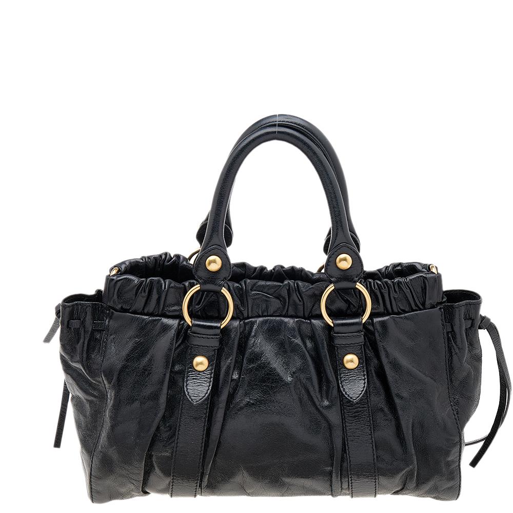 This tote from Miu Miu has alluring features. Crafted from Vitello Lux leather, the bag features dual top handles, a shoulder strap, and gold-tone hardware. The interior is lined with fabric and will hold all your belongings with ease.

Includes: