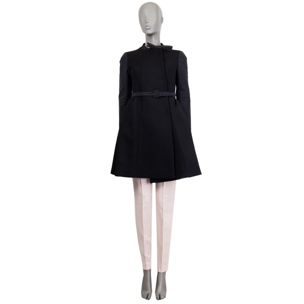 100% authentic Miu Miu double-breasted coat in black virgine wool (100%) with a belted waist, round neckline detailed with a ribbon, long sleeves in polyester (57%) acetate (43%) and a pleated botton. Lined in black viscose (100%). Closes with