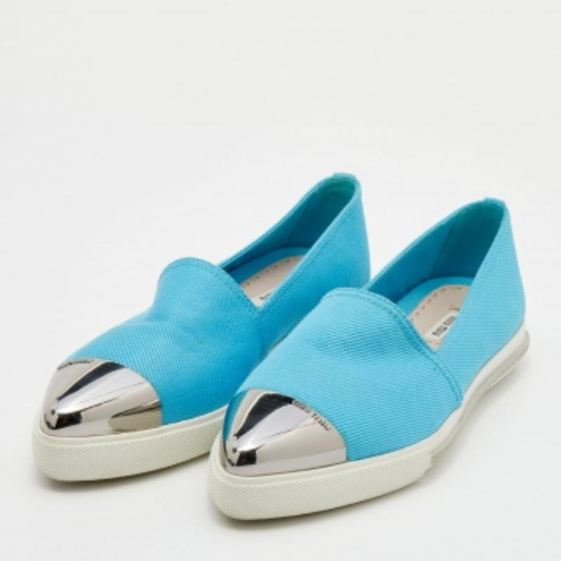 Let your next valuable investment be this pair of blue sneakers from Miu Miu. The shoes have been crafted from canvas and styled with metal cap toes. They come equipped with comfortable insoles and white rubber soles.