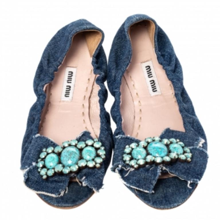 Ces ballerines Miu Miu sont vraiment magnifiques ! Ces chaussures plates bleues sont fabriquées en denim et présentent des orteils en amande ainsi que des ornements en cristal et des nœuds sur l'empeigne. Des semelles intérieures confortables