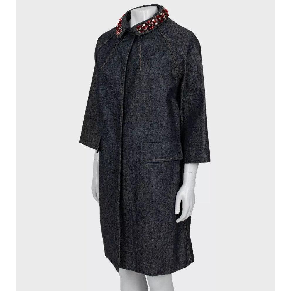 ¡Eleva tu vestuario con este impresionante abrigo vaquero de Miu Miu! Confeccionado en 100% algodón, este abrigo vaquero azul presenta una silueta clásica de corte recto, cierre de botones a presión y herrajes plateados. 

Los llamativos adornos de