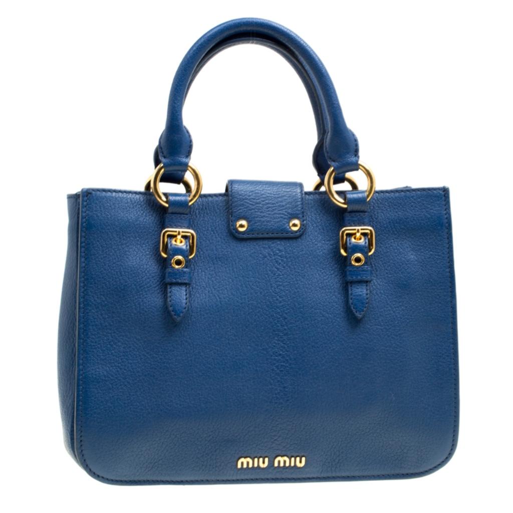 This elegant Madras tote from Miu Miu will make a valuable addition to your collection. The tote is crafted from blue pebbled leather and features a shoulder strap and dual round handles. The front flap closure opens to a suede lined interior. The