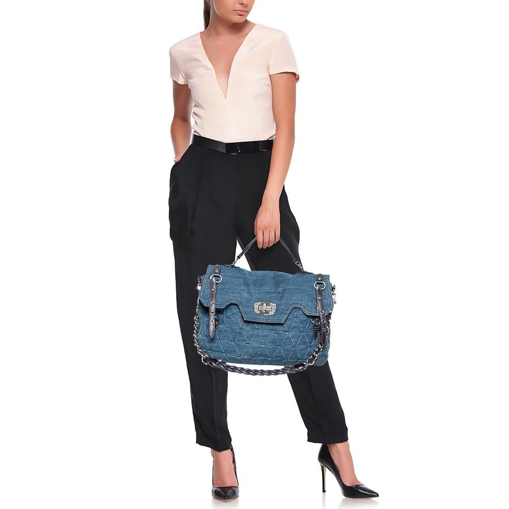 Crafted from denim fabric, this Miu Miu bag will become your favorite bag. Its quilted pattern and embellished turnlock on the front flap emit femininity and class. The silver-tone hardware is the perfect match to the blue color of the bag. It is