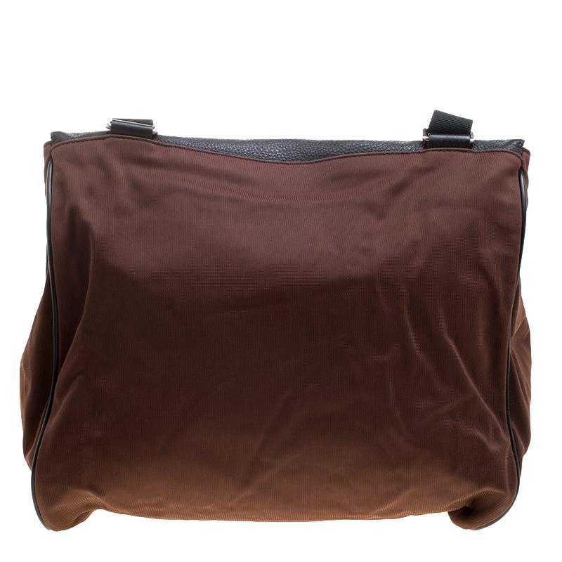Guys can now move round in style by carrying this classy messenger bag made from a combination of nylon and leather. It has a fleshy structure that provides the spacious interiors and also has a small front pocket. It can be closed with the slip