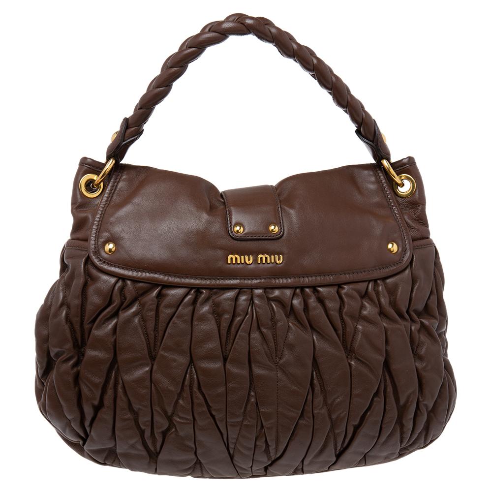 Miu Miu's coffer hobo is crafted from brown matelassé leather. The bag features a braided top handle, a detachable shoulder strap, and gold-tone hardware. The metal lock opens to a spacious fabric-lined interior.

Includes: Original Dustbag