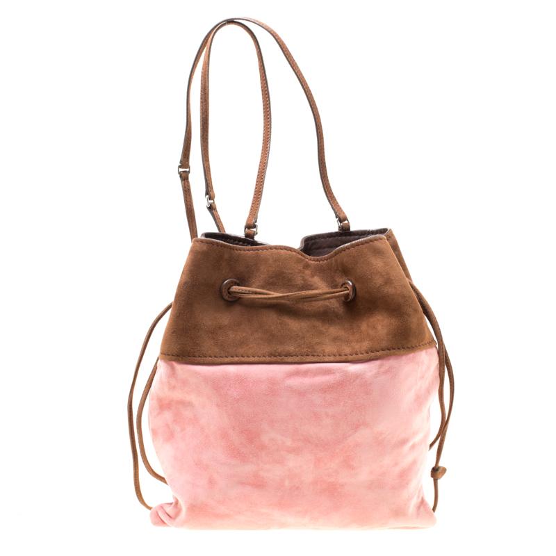 This wonderful Miu Miu design is made from suede flaunting a pretty combination of brown and pink hues and enhanced with silver-tone logo details to the front. The bag has a bucket shape with a drawstring closure that secures the leather-lined