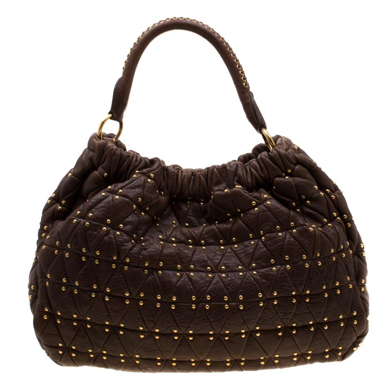 This Miu Miu hobo has a lovely shape and it comes in brown. The bag is created from quilted leather and detailed with studs all over, a top handle, shoulder strap, and a spacious satin interior for your essentials. It is gorgeous and ideal for daily