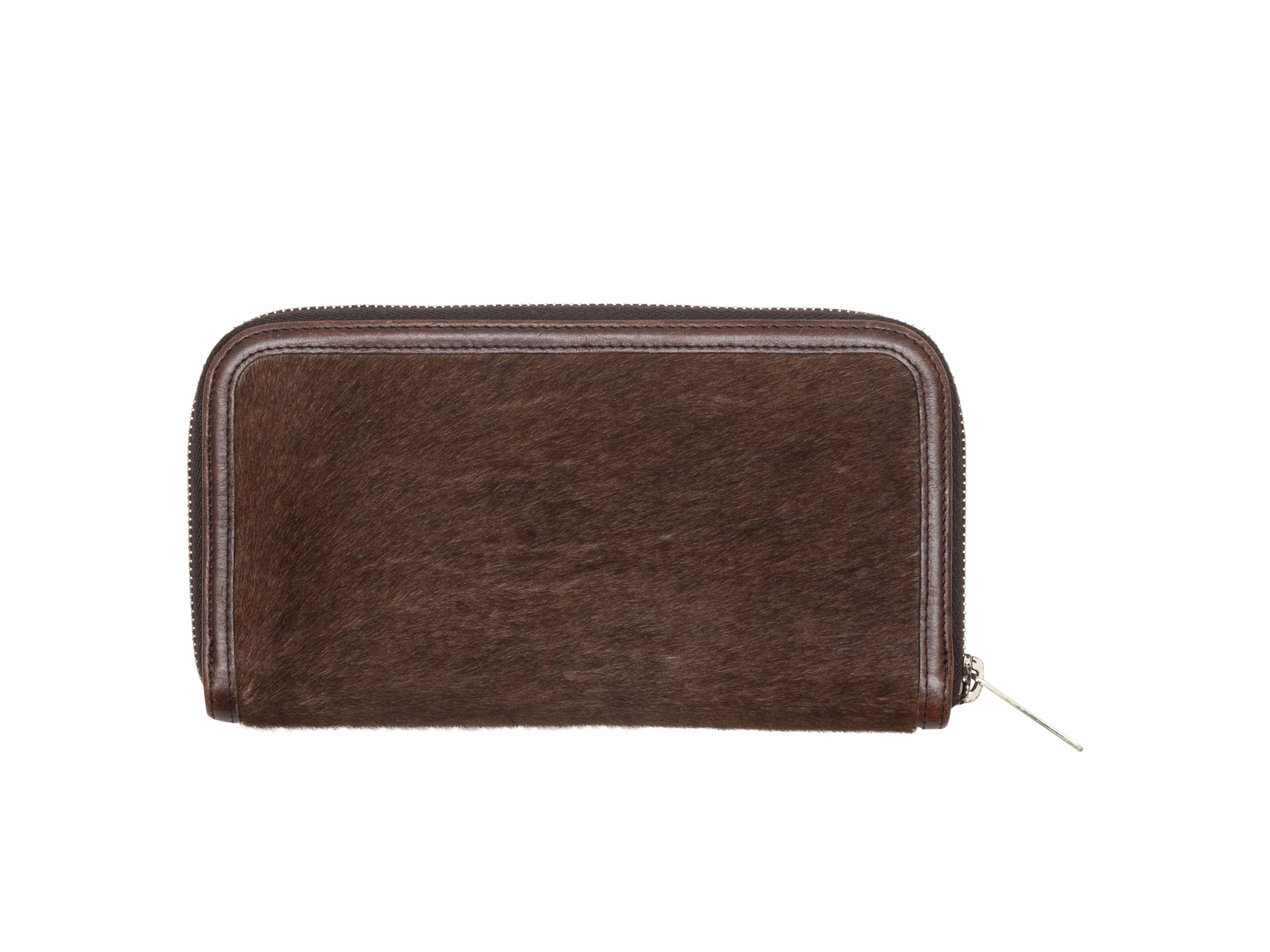 Product details: Brown and white ponyhair and leather wallet by Miu Miu. Interior card and cash slots. Zip closure at  outer edge. 4