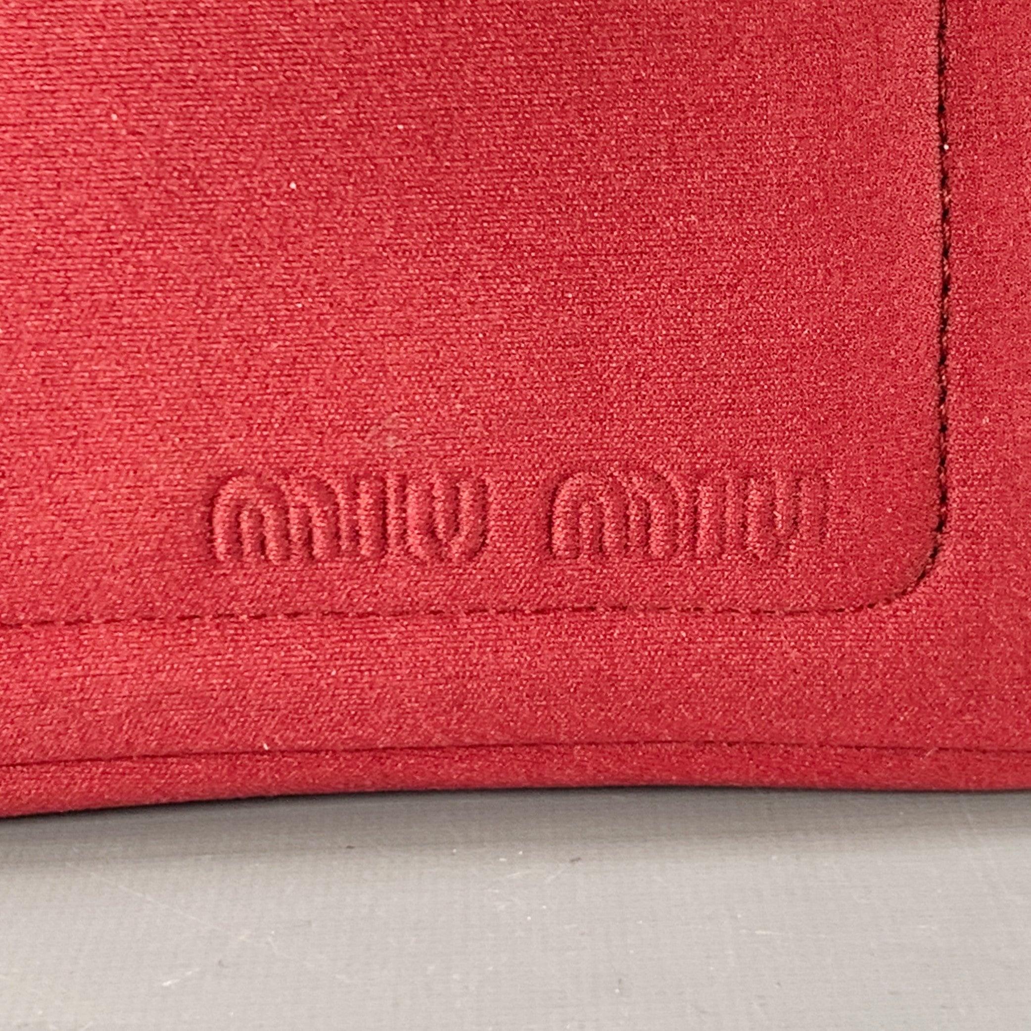 Borsa MIU MIU in nylon bordeaux con manico superiore in tela nera, tasca frontale per carte con zip e chiusura con zip. Piccolo segno sul retro. 

Misure: 
  Lunghezza: 7,75 pollici Larghezza: 3,5 pollici Altezza: 4,5 pollici Altezza: 6 pollici 
 