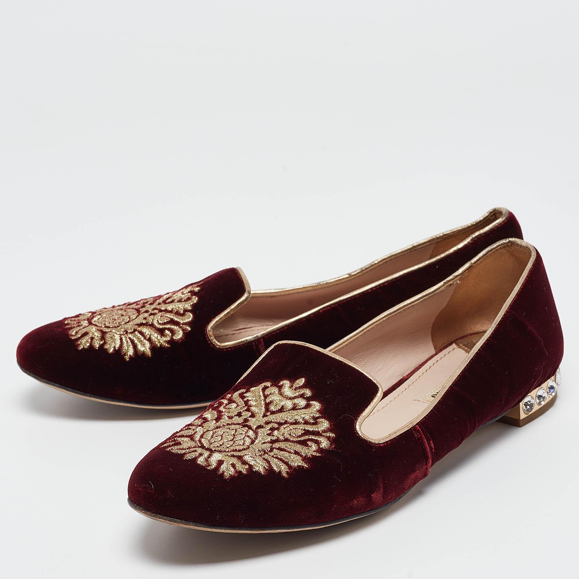 These eye-catching slippers by Miu Miu have been crafted in burgundy-colored velvet. They feature beautiful embroidered motifs on the vamps and the heels are embellished with crystals. The insoles are leather lined. Pair with formal or casual wear,