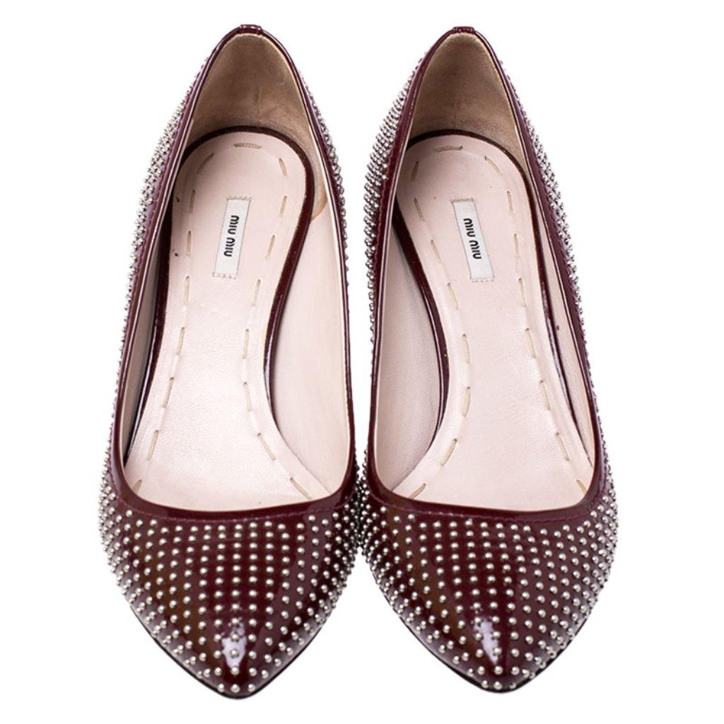 Crafted out of patent leather, these burgundy pumps will add a luxe touch to your overall look. They feature pointed toes, studs all over and 6 cm heels. This stylish pair from Miu Miu will make a perfect addition to your collection of