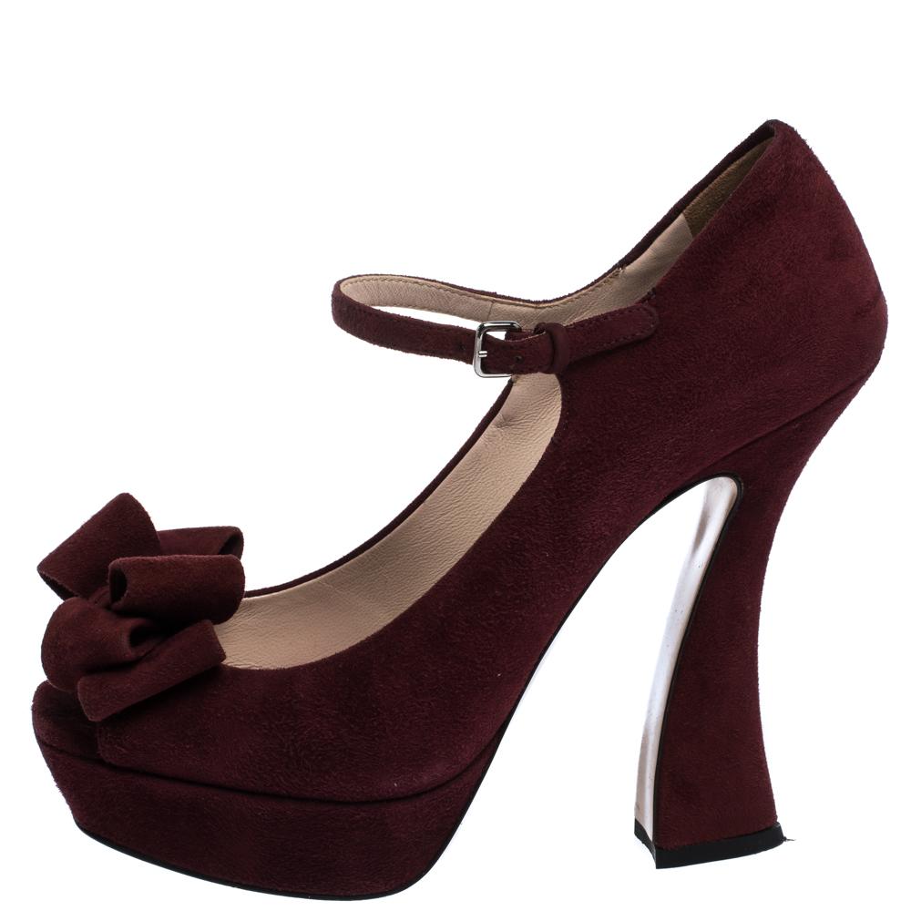 Scintillating, regal and standing tall like no other, these ravishing burgundy pumps from Miu Miu will enchant one and all! They are crafted from suede and feature peep-toes with a lovely bow detailing and a Mary-Jane style. They come equipped with