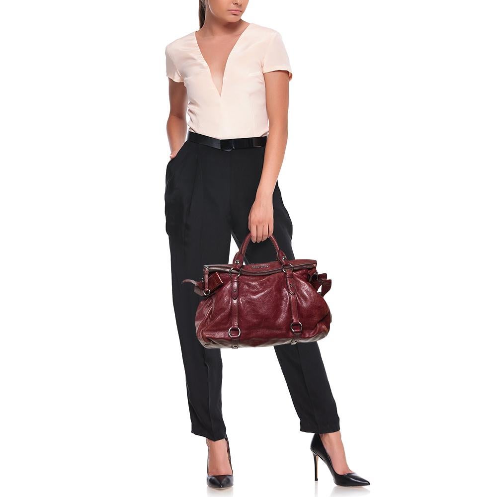 Functional and stylish, this Miu Miu satchel will be a great addition to your handbag collection. Crafted from Vitello Lux leather in a burgundy shade, it is equipped with a spacious interior for your essentials and dual handles.


