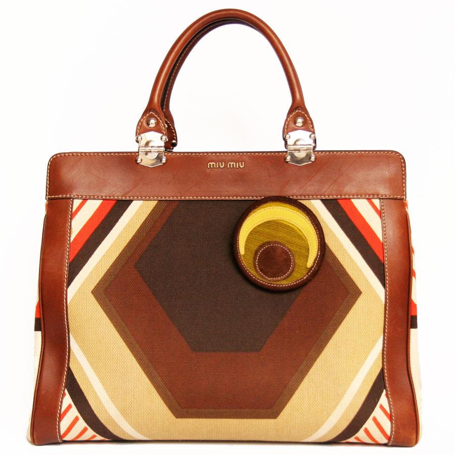 Large leather and fabric tote bag in Miu Miu brown tones. The jewelry is silver metal. It has been added to the 3-pin Miu Miu bag. It can be carried by hand or on the arm thanks to its two brown leather handles which each measure 36 cm. The inside