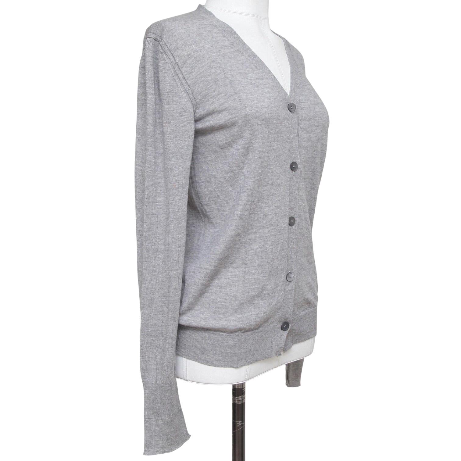 GUARANTEED AUTHENTIC CLASSIC MIU MIU GREY CARDIGAN

Details:
- Lightweight wool grey color button down cardigan.
- V-neck.
- Ribbing at neckline, sleeves and hem.
- Easy and year round great piece for your Miu Miu collection.

Size: 40

Fabric: 100%