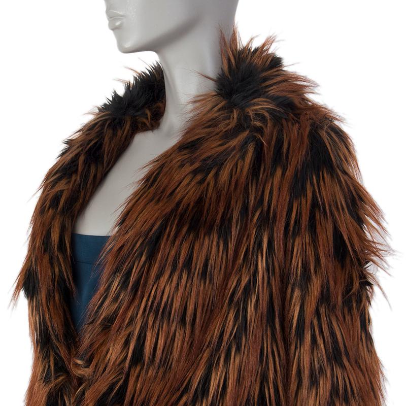 100% authentic Miu Miu shawl-collar faux fur jacket in cognac and black modacrylic (100%). With conceald stiring belt loops on the waist and two flap pockets on the front. Closes with concealed hooks on the front. Lined in black polyester (100%).