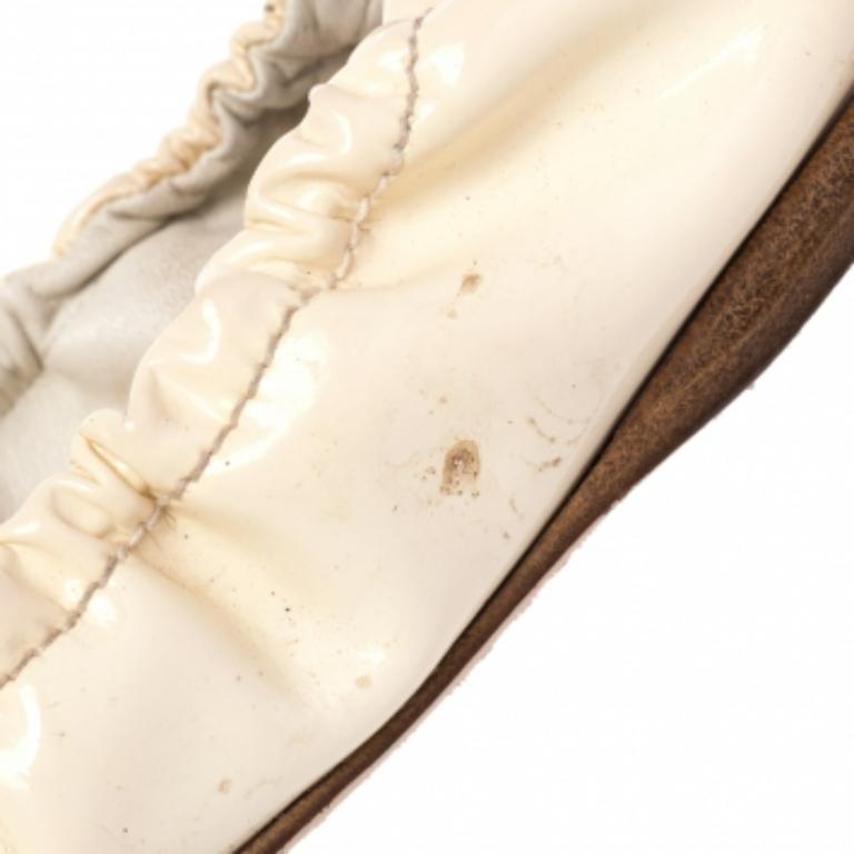 Step out gracefully with these Miu Miu scrunch ballet flats. They feature a cream patent leather upper with crystal embellishments fixated on the front. These flats will definitely add elegance to your overall look.