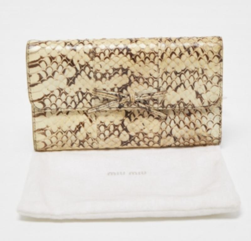 A stylish wallet is an everyday staple for all fashionistas! This compact wallet from the house of Miu Miu is crafted from watersnake leather and is equipped with a bow-adorned flap that reveals multiple slots to neatly carry your cash and cards.
