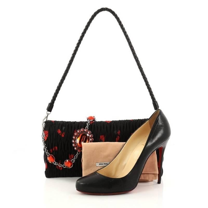 This authentic Miu Miu Crystal Clutch Matelasse Printed Fabric Medium is perfect for day to night looks. Crafted in black and red matelasse printed fabric, this feminine clutch features woven black leather shoulder strap, chain and crystal strap and
