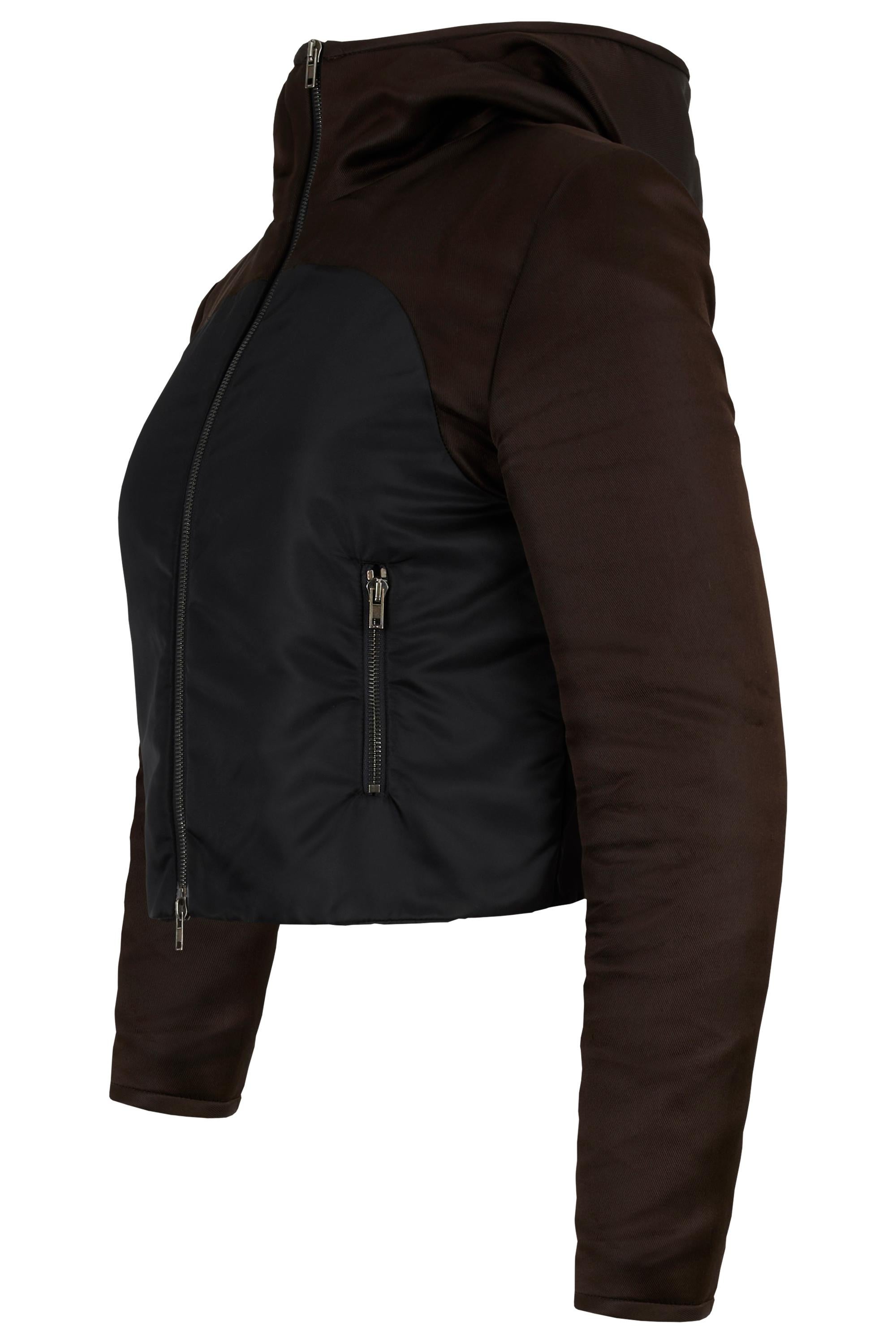From Miu Miu F/W 2008 collection, this hooded bicolour jacket is crafted in a rich contrast of dark brown and black technical fabric, the piece features a fitted silhouette with a cropped cut. Two side zip pockets and fastens with a front double zip