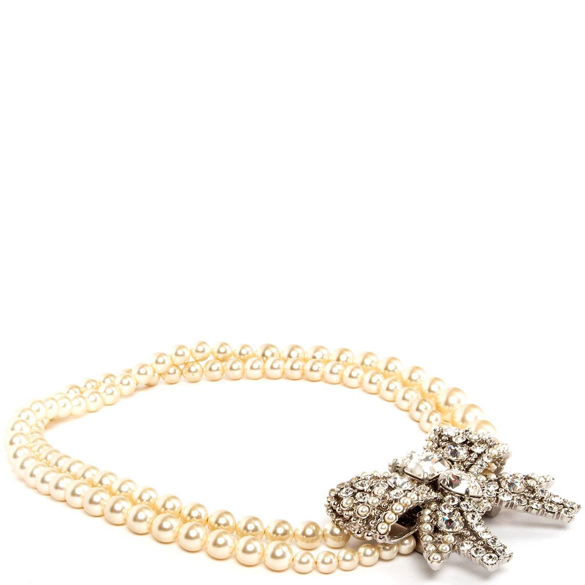 100% authentic Miu Miu bow rhinestone necklace from the Cruise 2012 collection is designed with faux pearls, clear Plexiglas crystals and opens with a silver-tone brass push clasp fastening. Has been worn and is in excellent condition. Comes with
