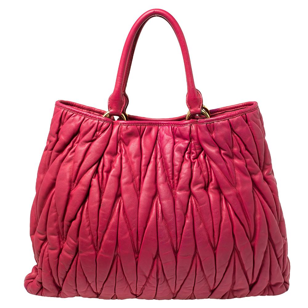 This chic and feminine tote is from Miu Miu. The bag is crafted from fuchsia pink leather in the signature matelasse pattern and comes with a satin-lined interior featuring a zip pocket and sized to fit your daily essentials. The tote is equipped