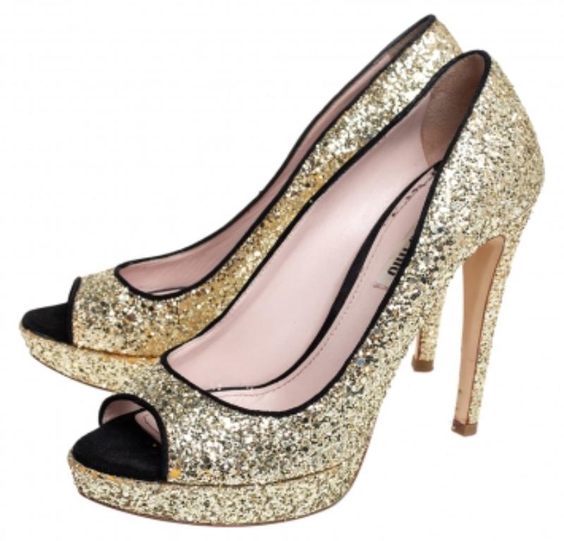 Designed with oodles of style for a fashionista like you, these Miu Miu pumps will help you outline a distinctive look. They are crafted from gold glitter and black suede into a peep-toe silhouette. Let them lift you gracefully with their 12 cm
