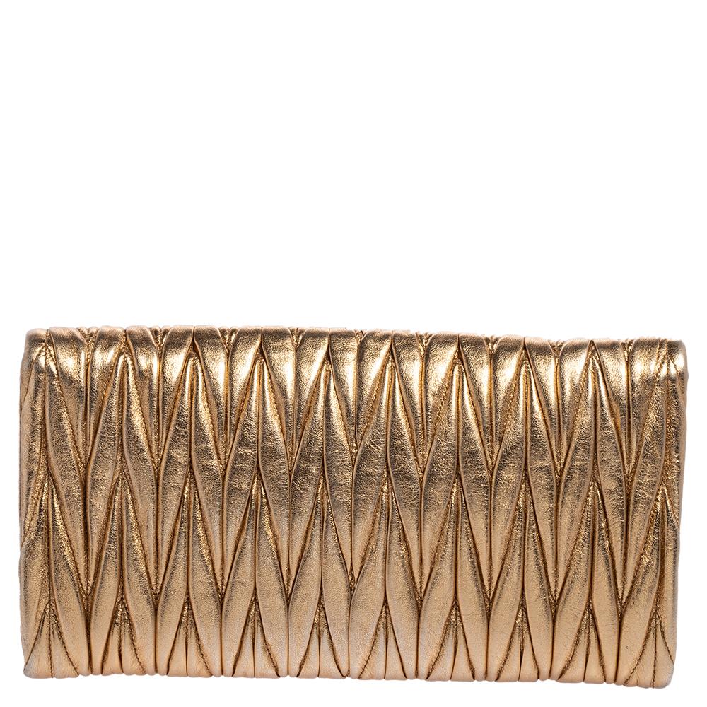 This clutch by Miu Miu is a creation that is not only stylish but also exceptionally well-made. Meticulously crafted from matelasse leather, it flaunts a gold exterior and a gold-tone logo detailed flap leading way to a satin interior that houses a