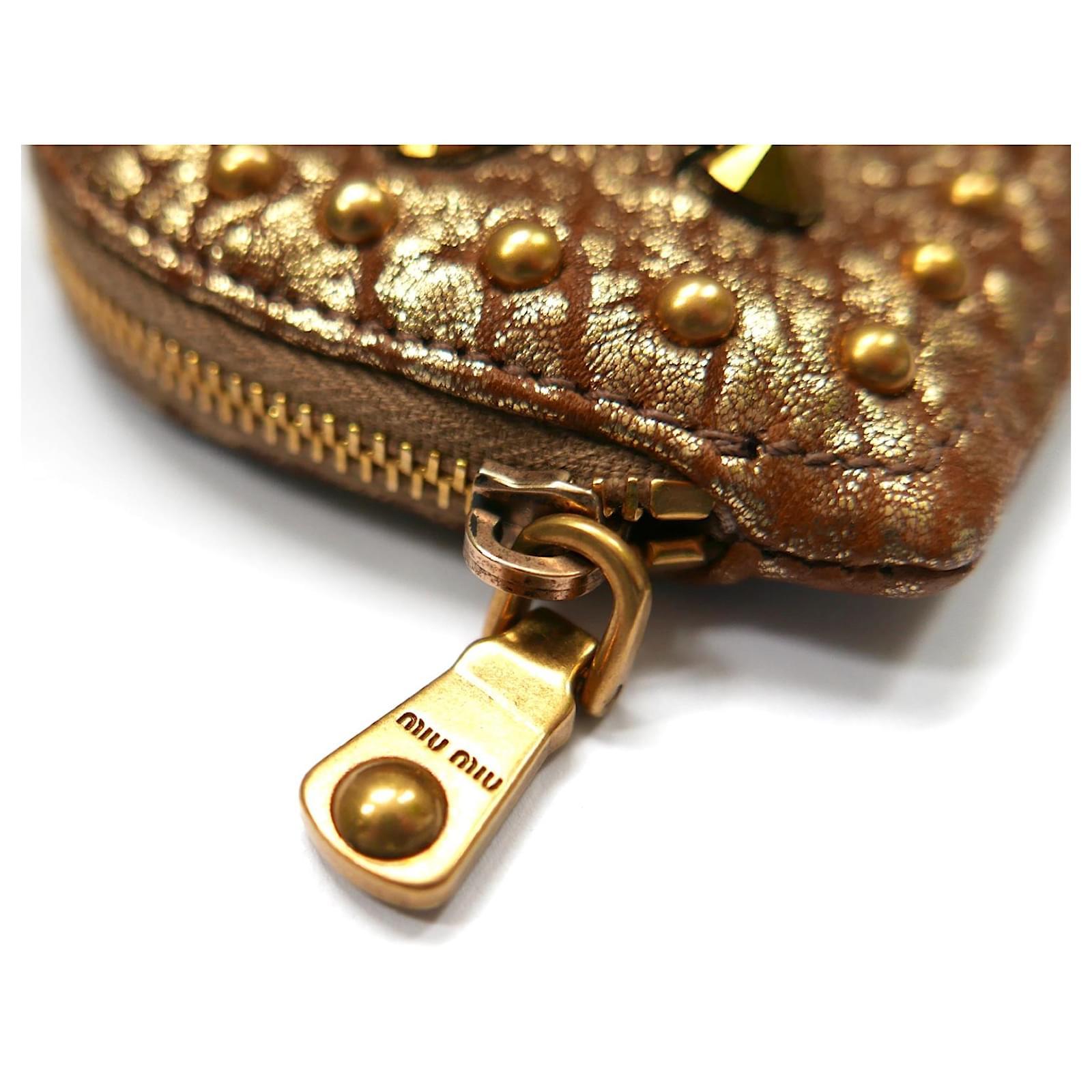 Adorable Miu Miu heart shaped coin purse - new with Net-A-Porter tag. Made from textured gold leather with studded front and chunky clip, keyring and fob. Lined in pink twill. Measures approx 4” x 3’


