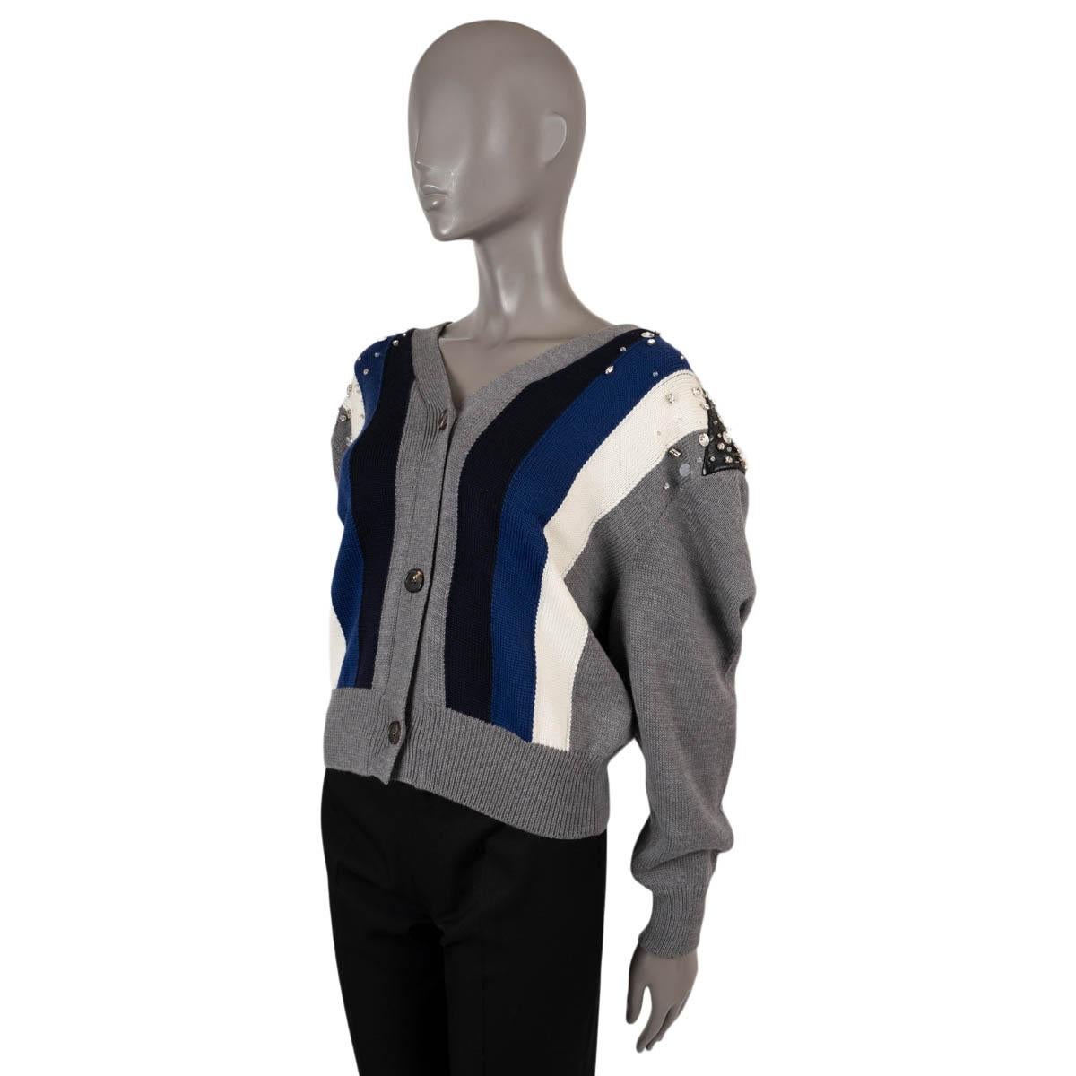 Cárdigan oversize 100% auténtico de Miu Miu en lana gris (100%) Con cuello de pico, parte delantera a rayas en blanco, azul marino y azul noche, parches de piel sintética en los hombros adornados con cristales redondos y cuadrados. 

Complejo