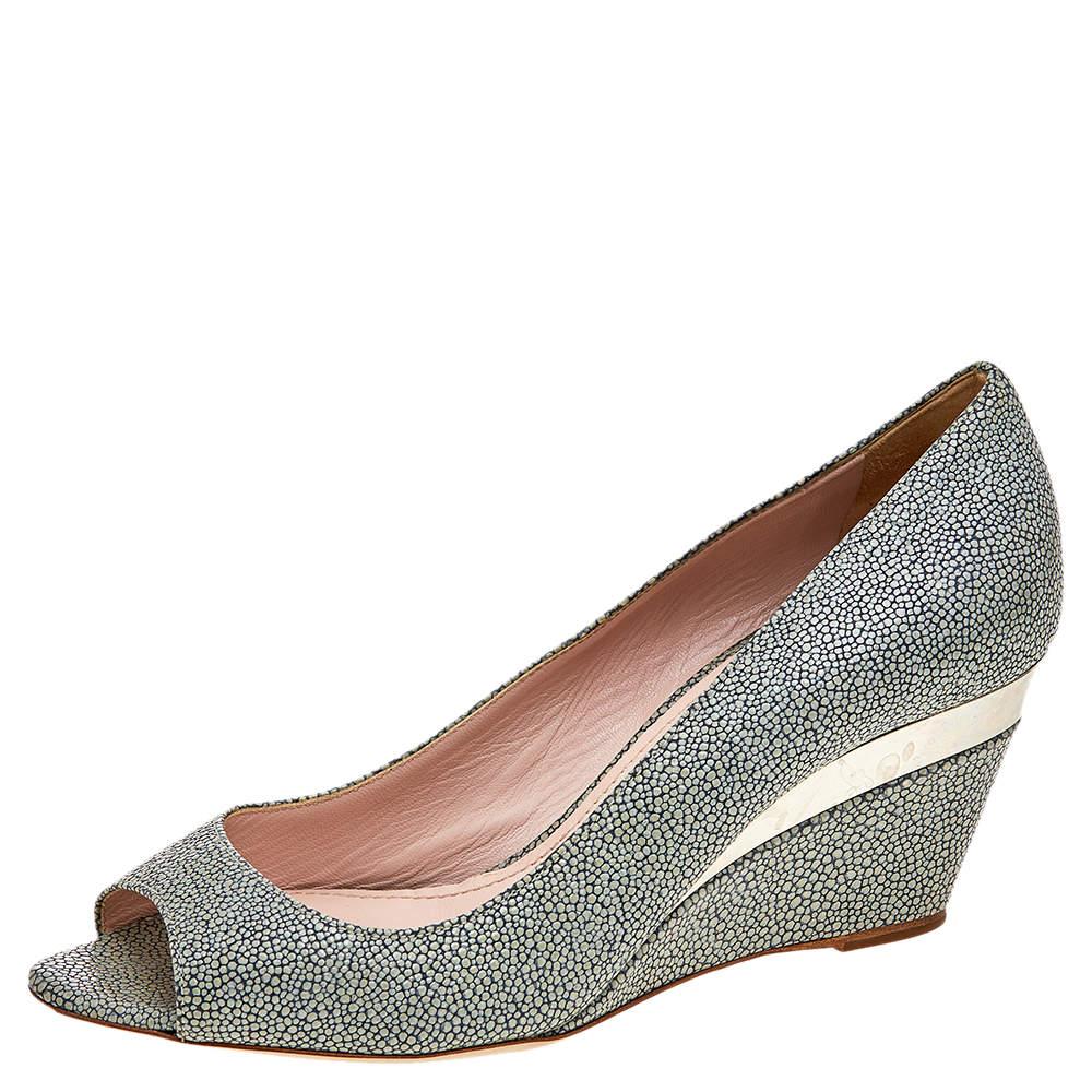 These pumps from the House of Miu Miu will leave you looking gorgeous! They are made from grey leather and flaunt peep-toes and tall wedge heels. These pumps are adorned with gold-toned hardware. Match them with your outfit and look gorgeous.