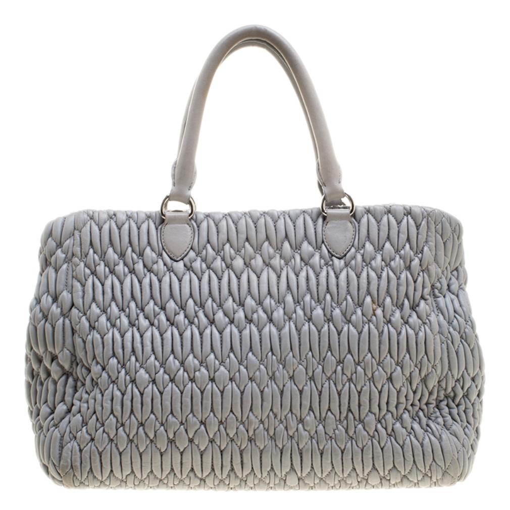 A beautiful spacious bag which is stylish enough for those day time parties and events, this Miu Miu tote is practical yet chic. Crafted in grey matelasse nappa leather, this bag features silver tone chain and crystal studded accent along the front