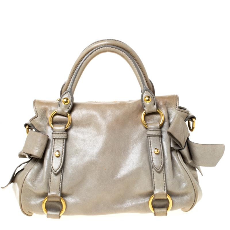 Diese Henkeltasche von Miu Miu besticht durch ihren modischen Look. Diese Handtasche aus Vitello Lux-Leder ist an beiden Enden mit Schleifen verziert und lässt sich mit einem Reißverschluss schließen, der ein geräumiges Inneres freigibt. Die mit