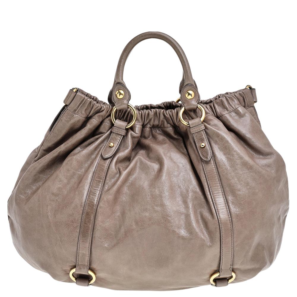 Instantly fall in love with this hobo with alluring features from Miu Miu. Crafted from leather, the bag features dual top handles, a shoulder strap, and gold-tone hardware. The interior is lined with fabric and will hold all your