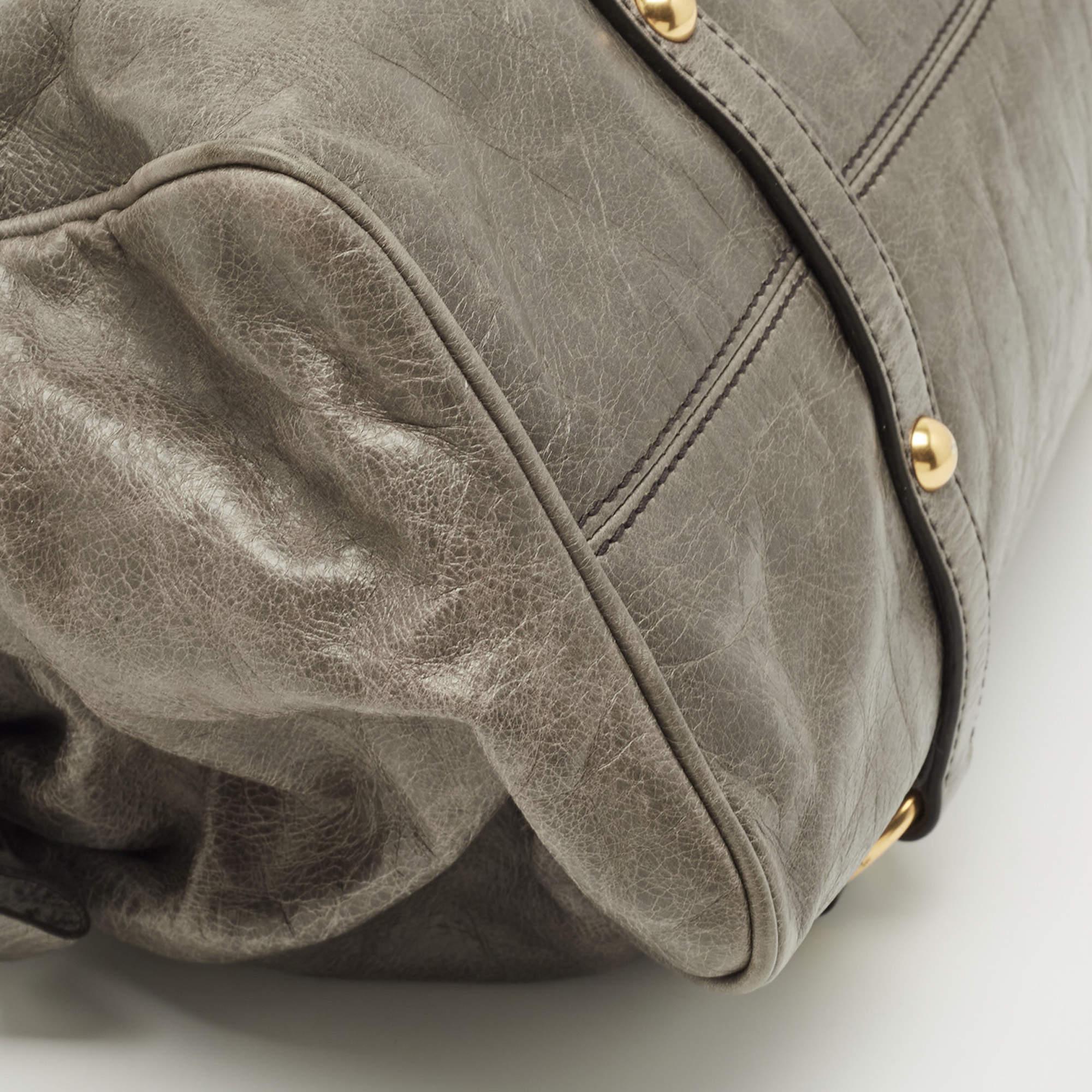 Diese schlichte Tasche von Miu Miu ist in Form und Design eine beliebte Ergänzung für Ihren Kleiderschrank. Sie wurde aus Vitello Lux Leder gefertigt und mit goldfarbenen Beschlägen minimalistisch gestaltet. Sie verfügt über zwei Griffe an der