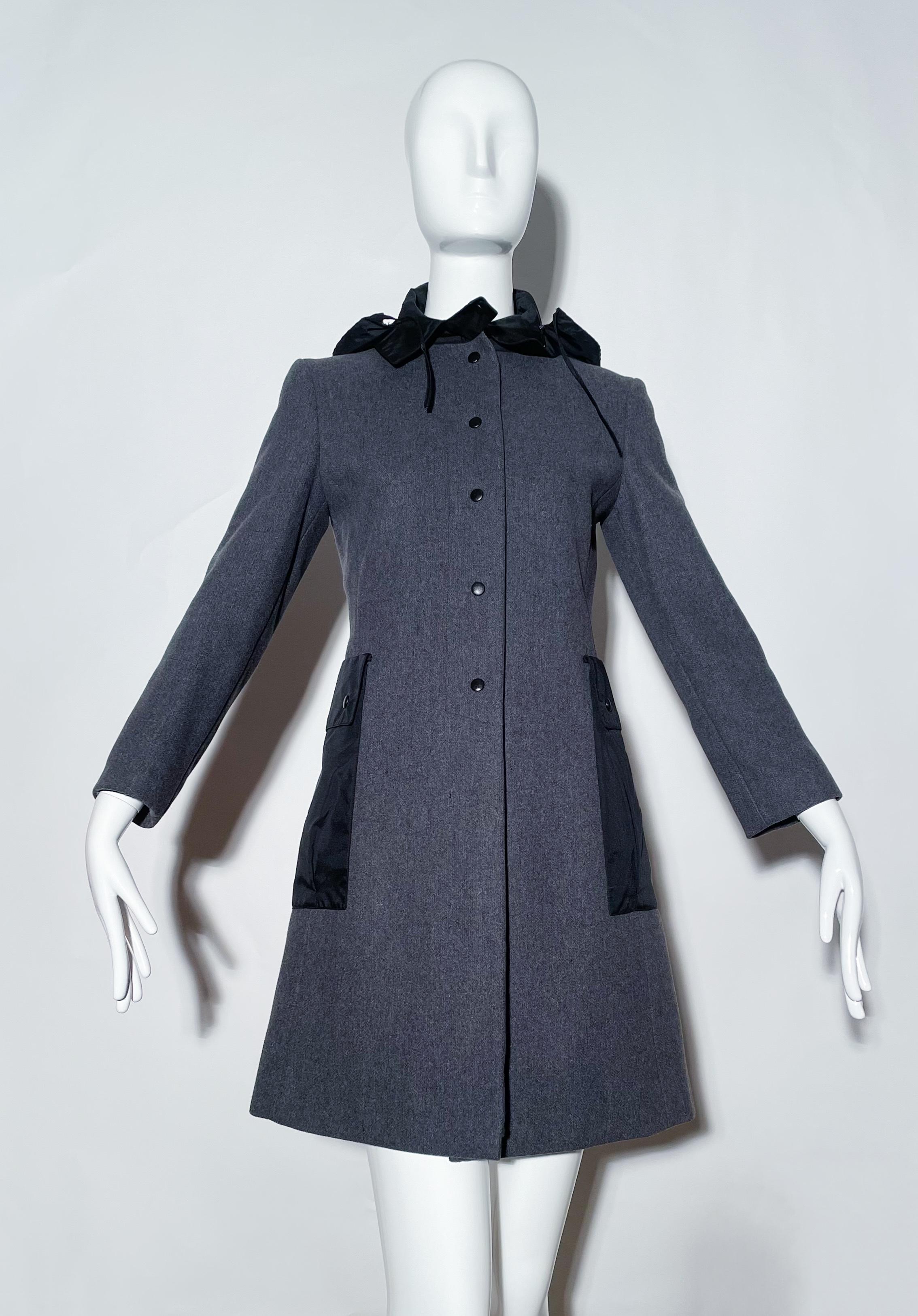 Grey coat with nylon hood and pockets. Front snap closures. Rear slit. Hood can no hidden. Lined. Wool. Made in Italy. 
*Condition: excellent vintage condition. No visible flaws.

Measurements Taken Laying Flat (inches)—
Shoulder to Shoulder: 16