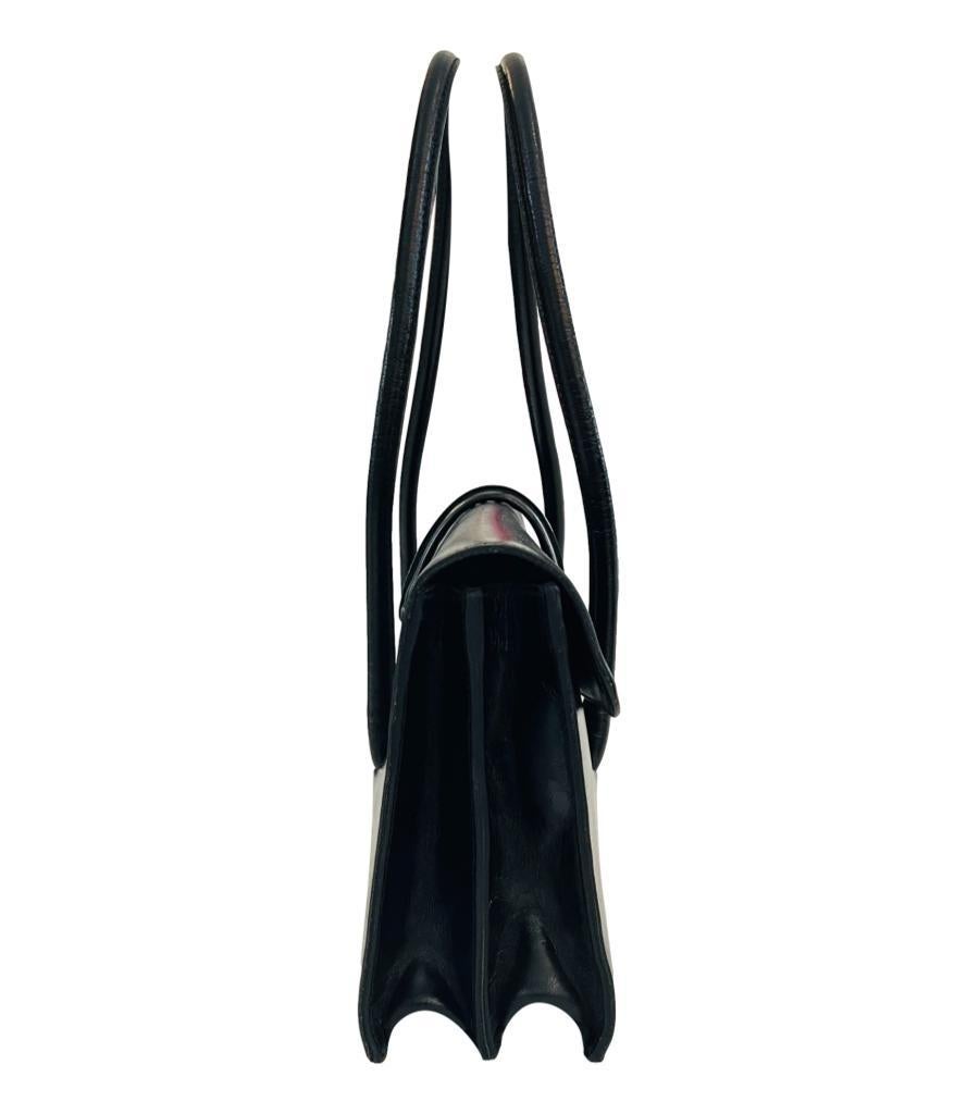 Miu Miu Leather Shoulder Bag
Black bag crafted in polished leather and detailed with silver logo engraved closure to the front.
Featuring dual top handle and front flap leading to two interior compartments.
Size – Height 18cm, Width 33cm, Depth