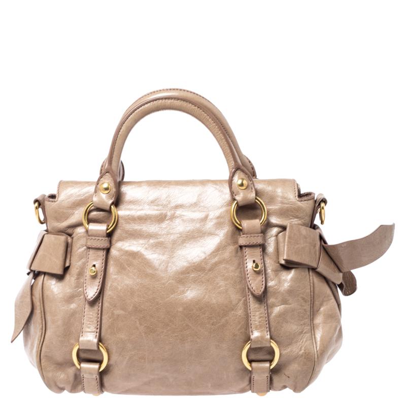 This bow satchel from Miu Miu flaunts a highly fashionable look. Made from Vitello Lux leather, this handbag features bows on each side and a top zip closure that reveals a roomy interior. Lined with satin and accented with gold-tone hardware, this