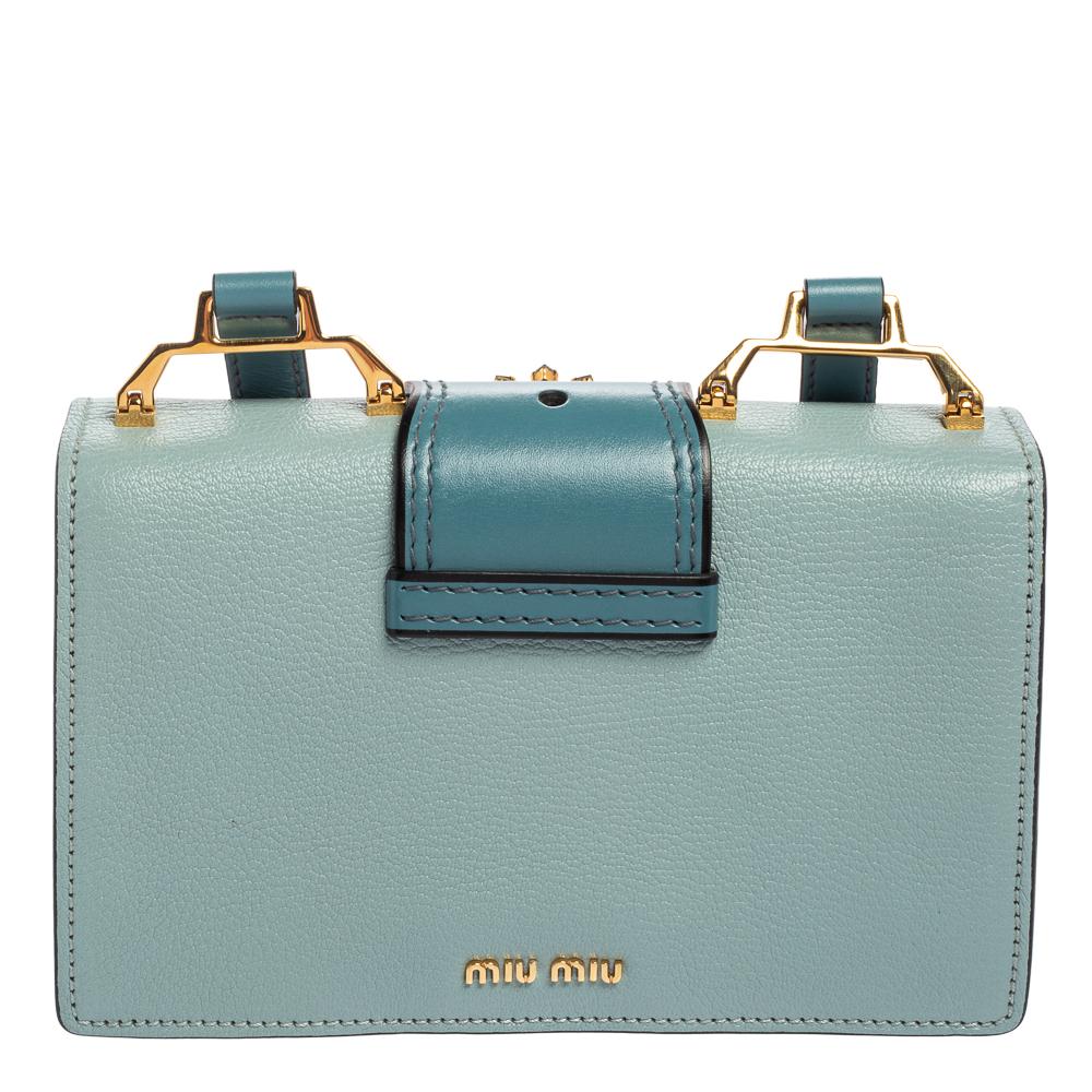 A pretty flap bag in two-tone blue leather highlighted by a crystal-embellished buckle on the front. It is held by a shoulder strap and lined with suede. The bag is a fine mix of quality and appeal. Add a touch of Miu Miu's youthful charm to your