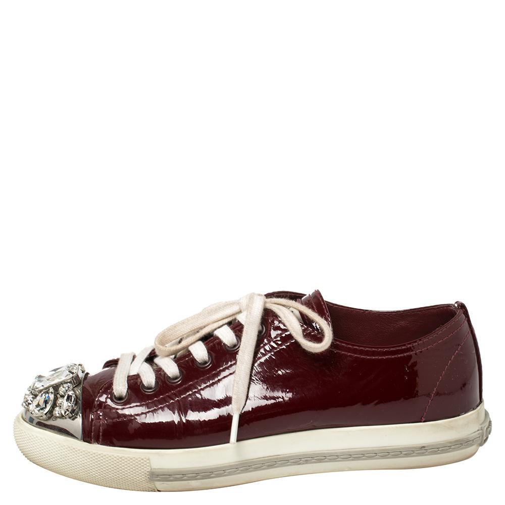 A signature Miu Miu style, these low-top sneakers for women are crafted in patent leather and detailed with crystals on the cap toes. They are secured with lace-ups and set on durable rubber soles.

Includes: Original Dustbag, Original Box, Info