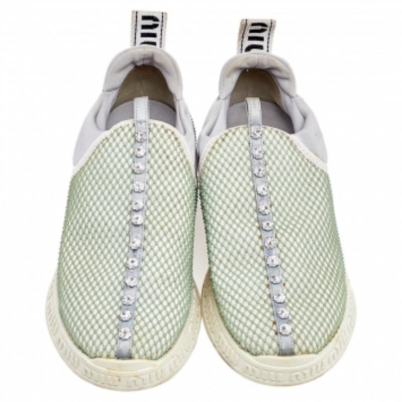 Slip in these Miu Miu sneakers to know how comfort can be blended with style. Crafted with quality materials, these white slip-on sneakers have crystal embellishments through the vamps and brand-inscribed, contrasting midsoles. They feature pull