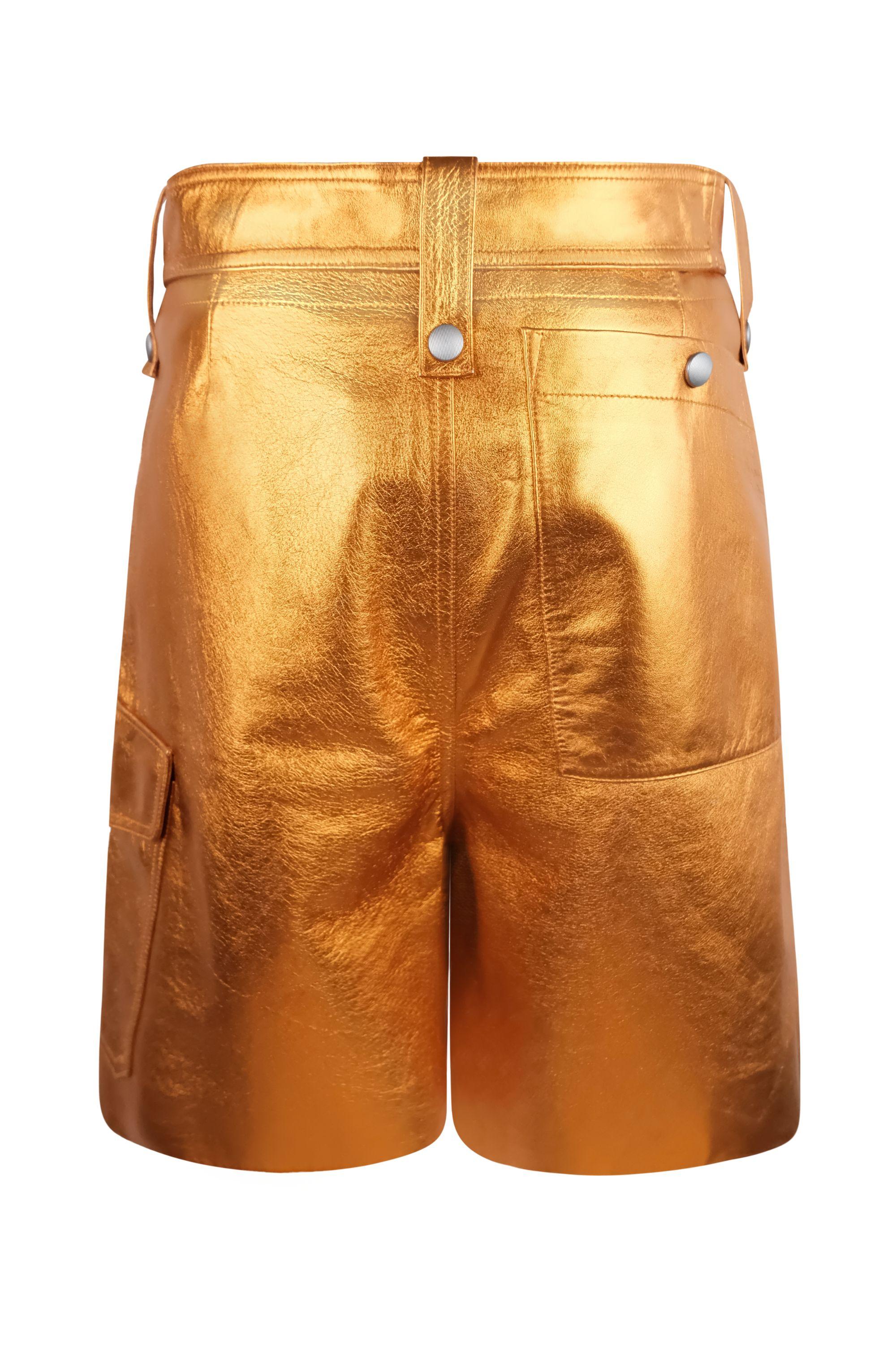 These Miu Miu leather cargo shorts in bold metallic orange feature a high-waisted silhouette with a shiny finish. The shorts have a bermuda length fit and are equipped with functional details, including multiple pockets with silver-tone snap