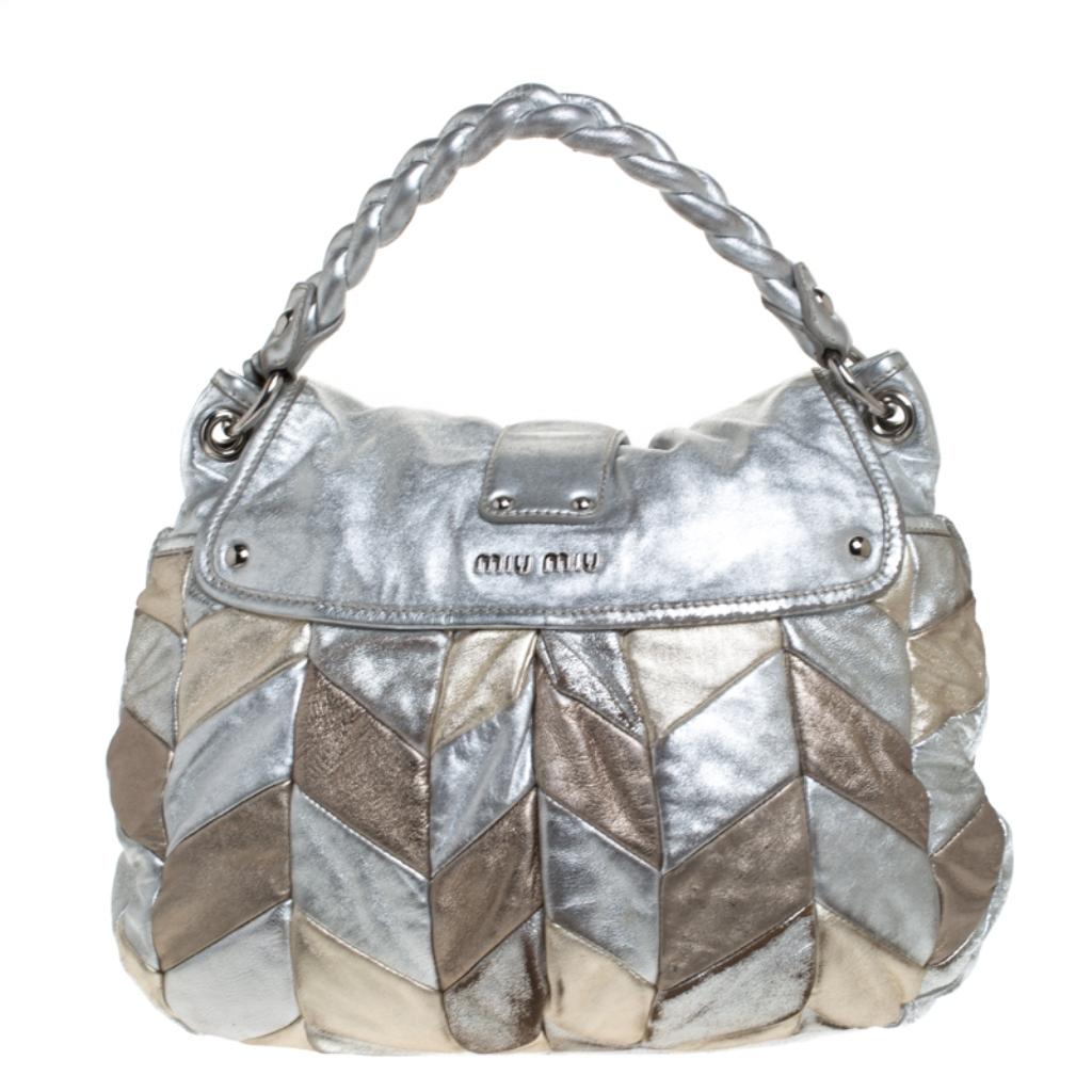 This chic and feminine Coffer hobo is from Miu Miu. The bag is crafted from silver and gold leather and features a flap secured with a gold-tone push-lock closure. The bag opens up to a fabric-lined interior sized to fit your daily essentials. The